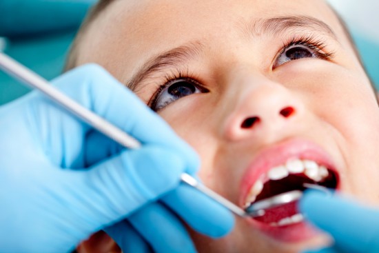 Kid at the dentist getting his teeth checked