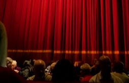 move audience looking at red curtain