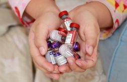 Cupped hands holding multiple vaccine vials