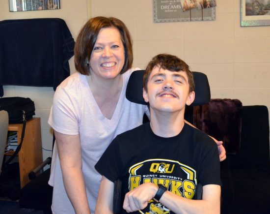 Cheryl and Jacob Flynn smiling together in their Quincy University apartment.