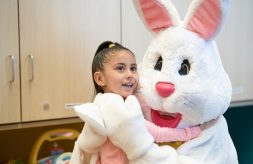 Little girl smiles while hugging the Easter Bunny