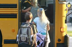 Three students boarding a school bus