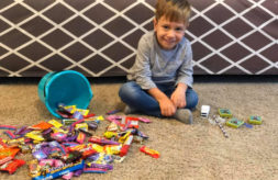 Axel Johnson sits with an overturned bucket of Halloween candy that he cannot eat