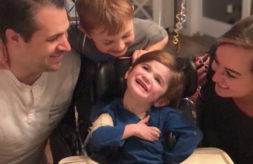 Nash Stineman smiles while surrounded by his mom, dad and older brother.