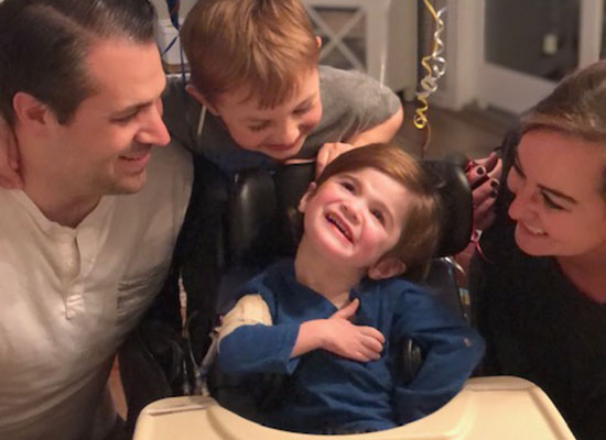 Nash Stineman smiles while surrounded by his mom, dad and older brother.