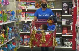 Shyterria Jordan pushes a decorated shopping cart with her son T'Aubrae and his big brother inside during a shopping spree