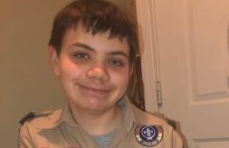 Nathan Lichucki smiles while wearing his Boy Scouts uniform