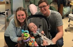 The Wolff family smiles and poses together in a hospital room