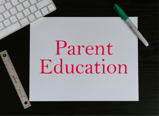 The text "Parent Education" on a sheet of paper next to a computer keyboard, ruler and marker